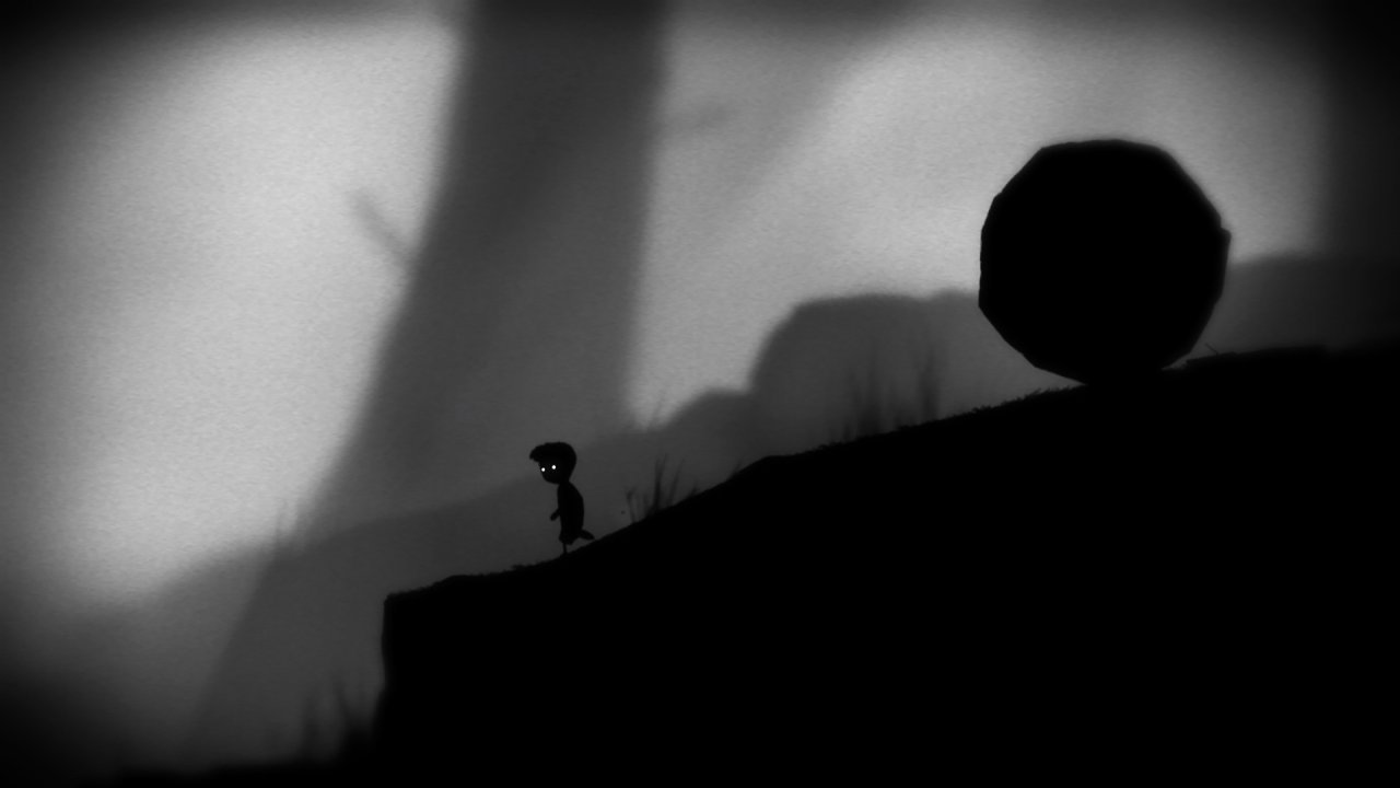 Silhouetted boy facing massive rolling boulder