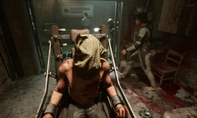 A man restrained on chair in a horror game