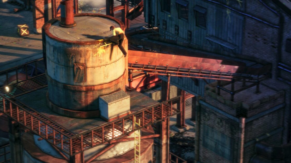 A person climbs a large industrial tank in a factory setting