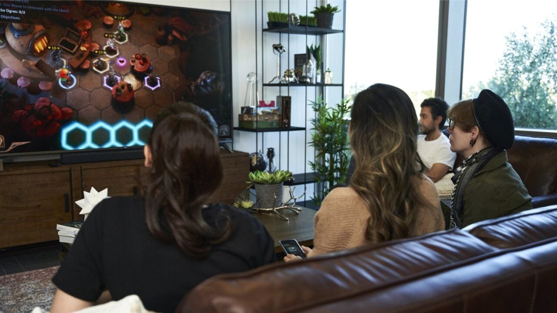 A group of friends playing Sunderfolk video game on a TV