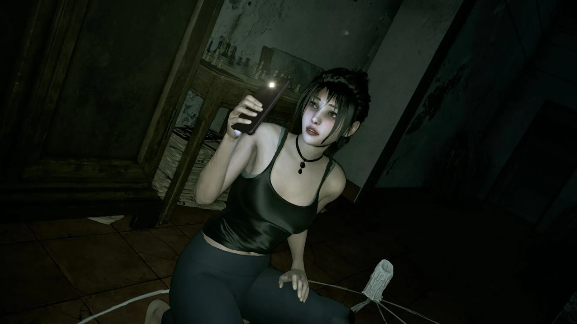 Linda sitting on floor with flashlight in DreadOut 3