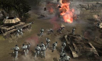 I soldati avanzano attraverso un campo di battaglia con carri armati ed esplosioni in un gioco RTS per dispositivi mobili