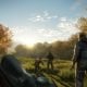 Cazadores con rifles exploran un claro del bosque iluminado por el sol en el juego de simulación de PS Plus
