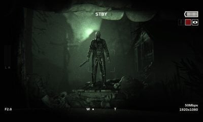 Nachtsichtansicht einer bedrohlichen Gestalt mit einer Waffe, die in einer Horrorspielszene von PS Plus über Leichen steht