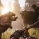 Escena de combate prehistórico con un oso y un gato dientes de sable peleando en el juego de supervivencia de PS Plus
