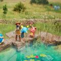Deux villageois de Palfarm pêchent près d'un étang tandis que les créatures célèbrent leur prise sur les rochers