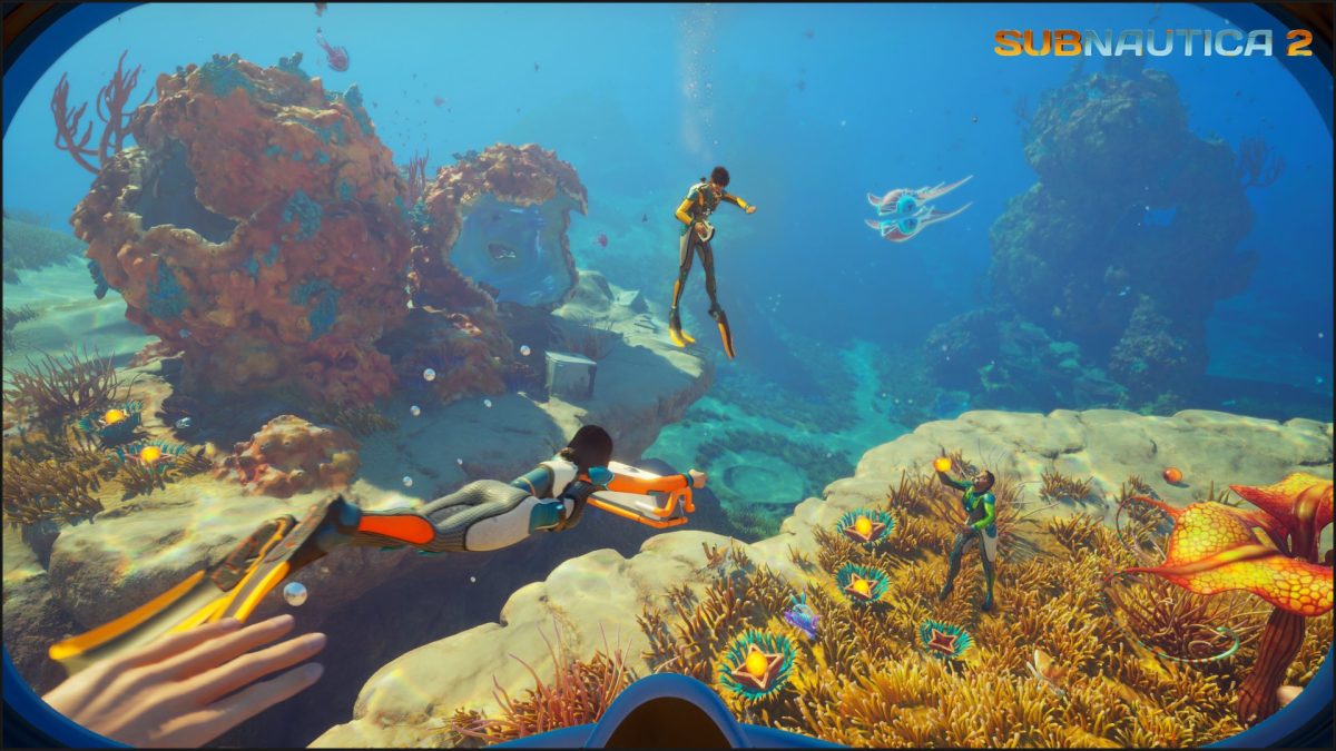 Three divers swim through vibrant coral habitats in Game Pass crossplay game