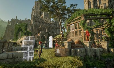 Players construct stone walls together beside a large castle and ivy-covered workshop in Enshrouded.