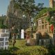 Players construct stone walls together beside a large castle and ivy-covered workshop in Enshrouded.