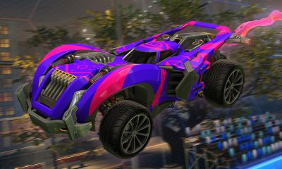 A purple and pink rocket-powered car flies above a Rocket League stadium with a bright boost trail.