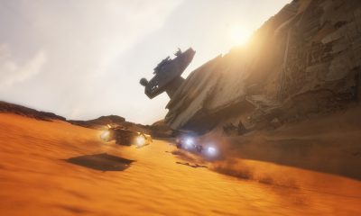 Two racing vehicles speed across orange desert sand beside a massive wrecked starship in Star Wars: Galactic Racer.
