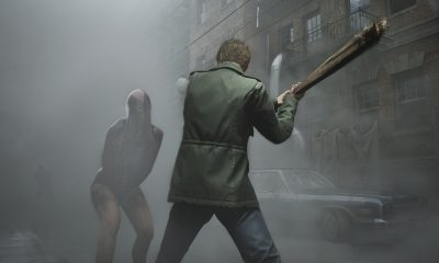 James Sunderland holds a wooden weapon in a foggy street as a creature approaches in Silent Hill 2.