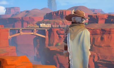 A builder in a broad-brimmed hat looks across the desert landscape near Sandrock.