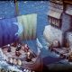 A small party stands on stone platforms beside colorful hanging banners in a tactical fantasy setting.