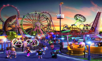 Blocky Roblox characters explore a theme park with colorful rides and roller coasters at sunset.