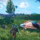 A space traveler stands beside a landed starship on a grassy planet in No Man's Sky.