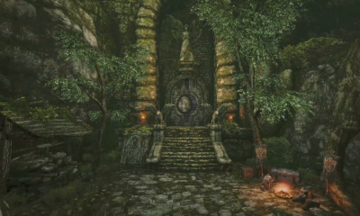 Stone steps leading to an overgrown ruined entrance beside a campfire in Queen’s Domain.