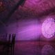 Purple light illuminating a vaulted chamber and circular window in Lunacid.