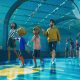 Visitors walk through a blue-lit aquarium viewing tunnel in Planet Zoo 2.